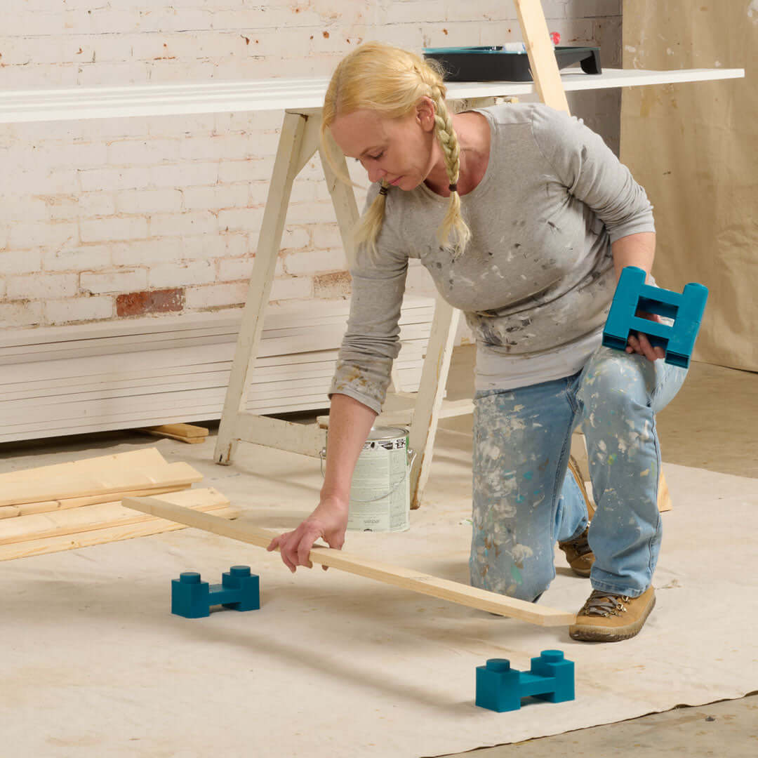 Painter using PaintBlox Pro drying blocks to elevate painted parts during drying on a job site.