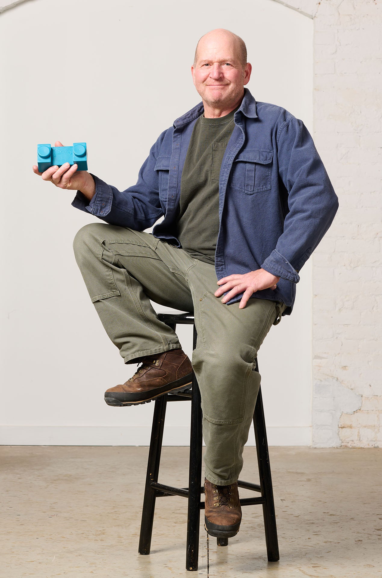 Founder Gavin A. Cook sitting on a stool with ne of his PaintBlox in hand.