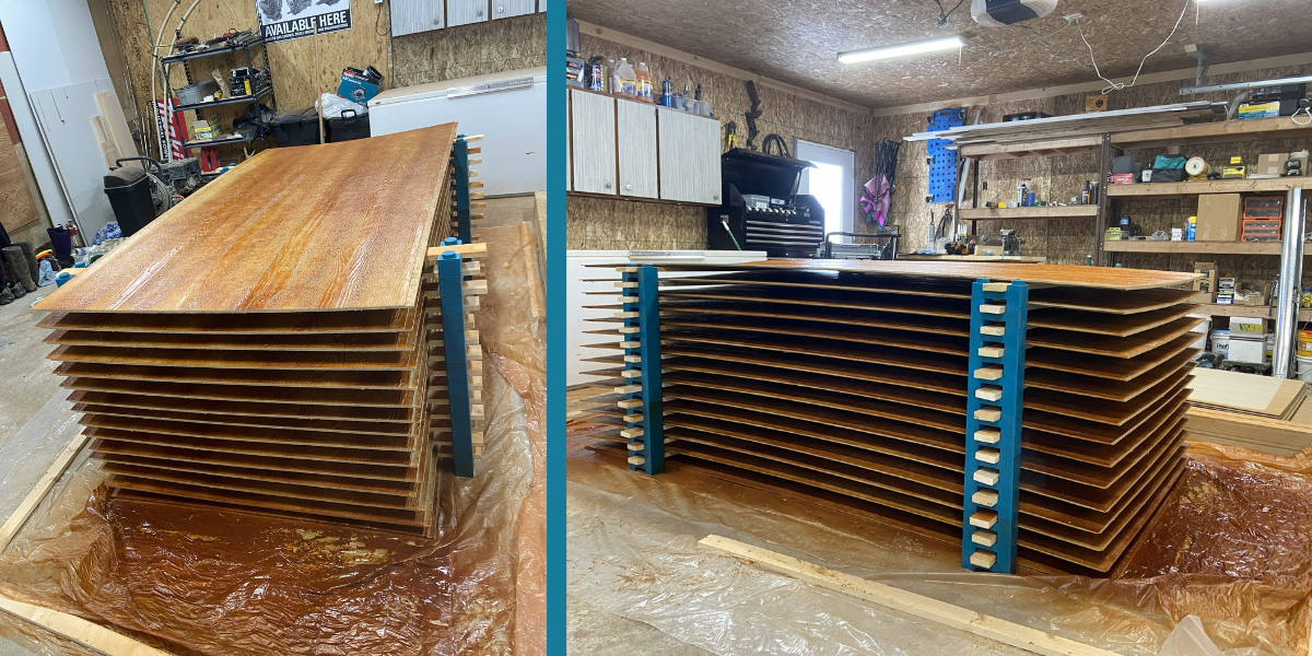 Fifteen 4x8 SmartSide panels drying in stacked layers on PaintBlox Pro supports
