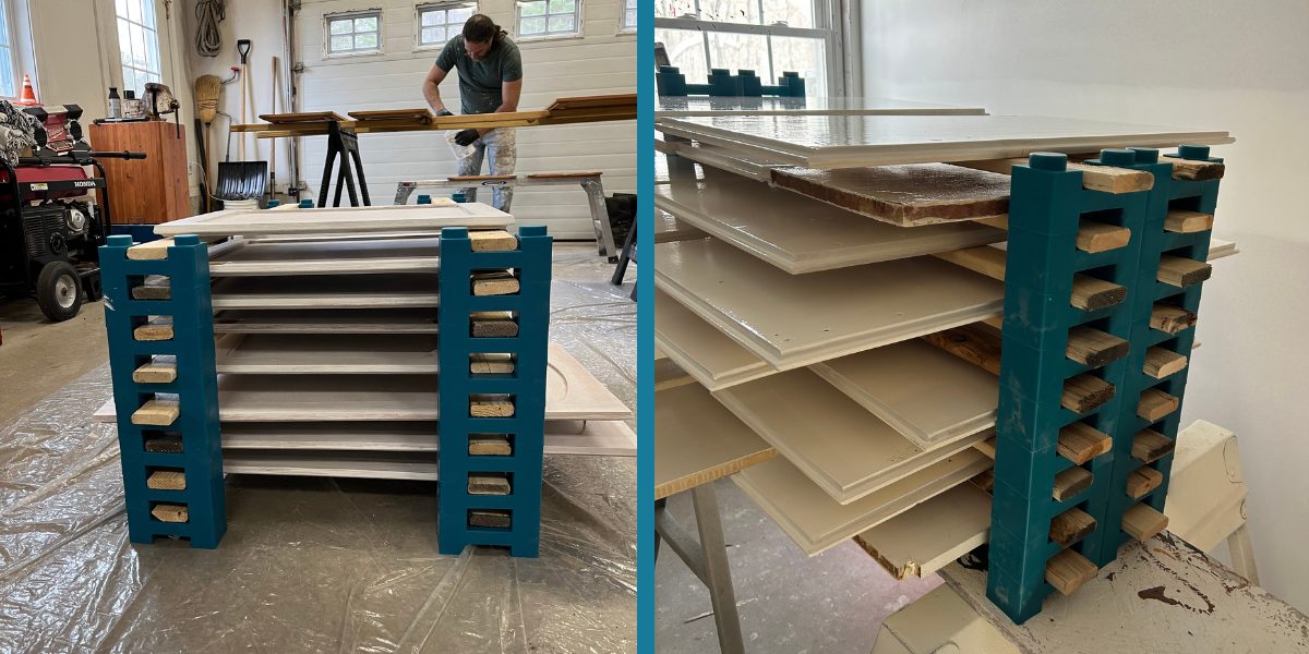 Kitchen cabinet doors of mixed sizes drying in stacked layers on PaintBlox Pro supports