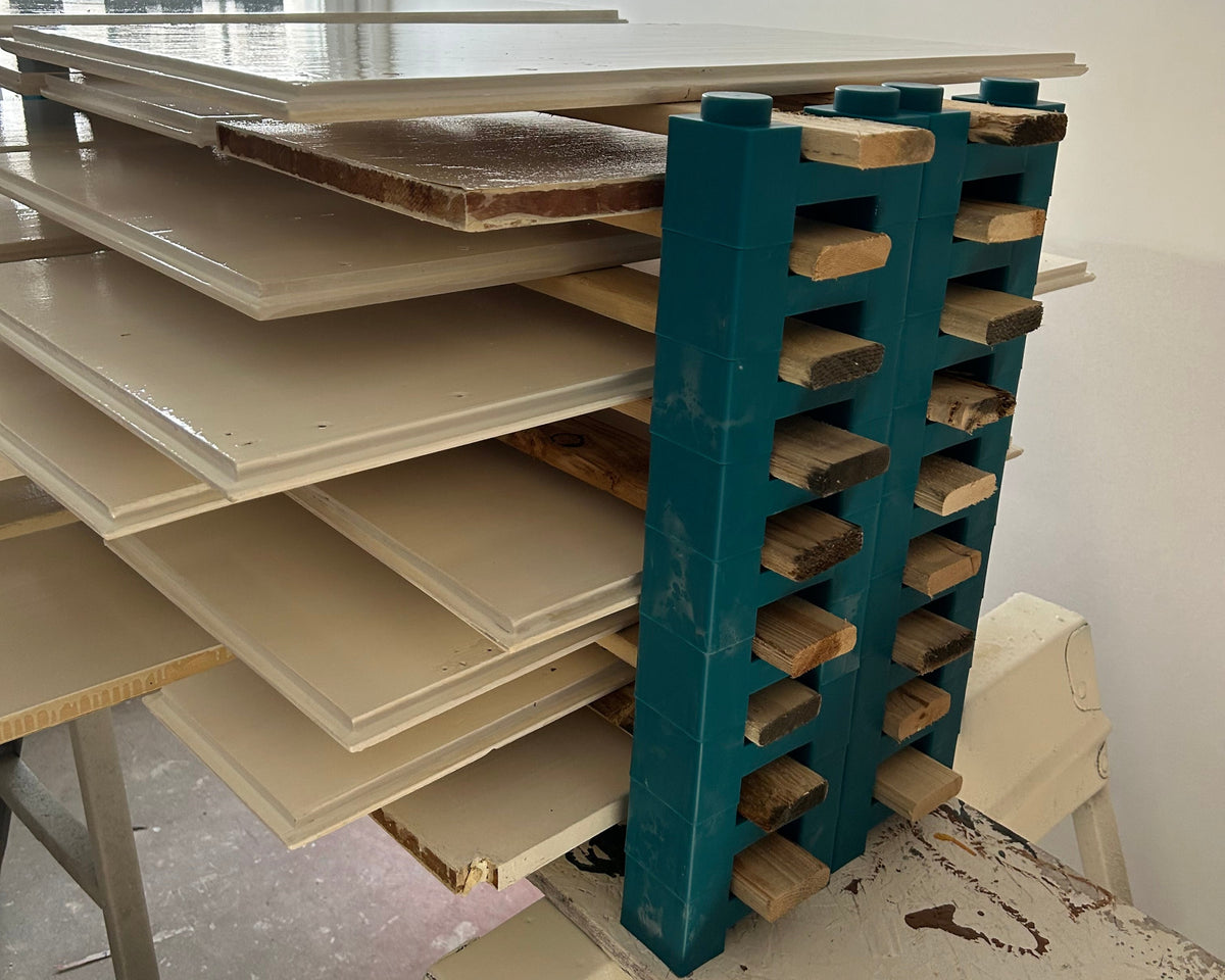 A professional cabinet door drying rack built with PaintBlox Pro Crew 72 blocks, stacking freshly painted cabinet doors.
